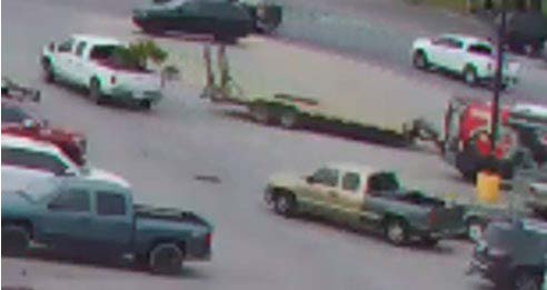 Home Depot camera footage photo of parking lot with tan Chevy Silverado with a gray bed and a white Ford F250. 